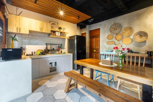 库塔Interconnection Hostel的厨房配有木桌和木板凳