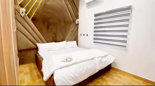 瓦里CEO HOMES AND APARTMENT的一间卧室配有带白色床单和枕头的床。