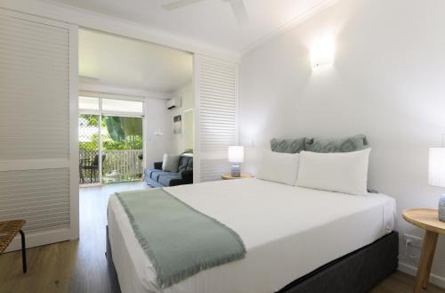 道格拉斯港Ocean Palms Apartments的一间带一张白色大床的卧室和一个阳台