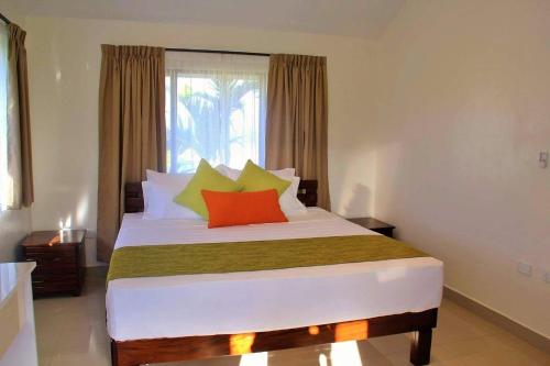 南迪Bula Villas的一间卧室配有一张带色彩缤纷枕头的大床