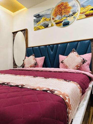 巴夫那加尔HOTEL E CLASSICO的一间卧室配有一张带枕头和镜子的紫色床