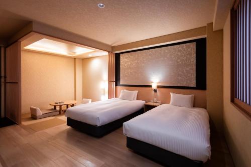 京都Rinn Kiyomizu Gion的酒店客房设有两张床和一张桌子。