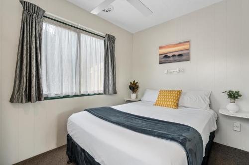 米兰达Tasman Holiday Parks - Miranda的一间卧室设有一张大床和一个窗户。