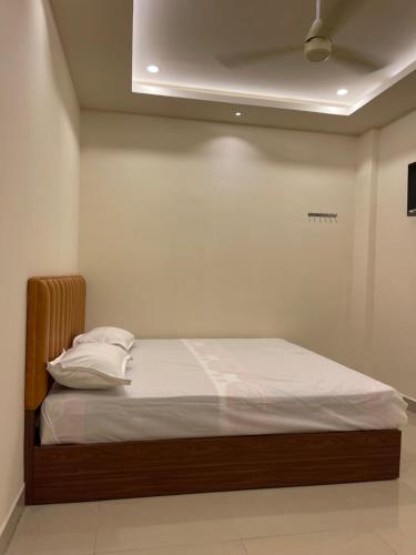 钦奈KM MANSION的一张带白色床单和枕头的床