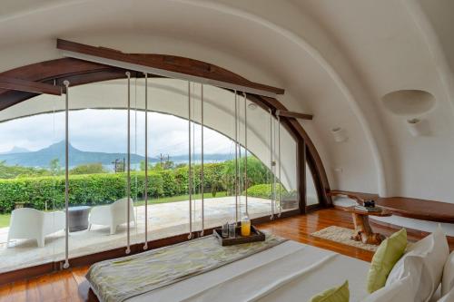 罗纳瓦拉Resort Amanzi的拱形客房设有大窗户和沙发