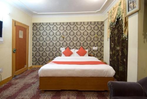 斯利那加hotel city plaza的一间卧室配有一张带红色枕头的大床