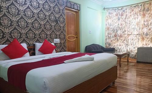 斯利那加hotel city plaza的一间卧室配有一张带红色枕头的大床