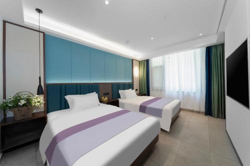 凤凰凤凰最佳江景民宿的配有两张床的酒店客房中的两张床
