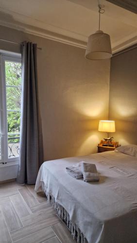 Eyguièresbastide St Joseph的一间卧室配有一张带灯和窗户的床