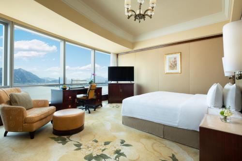温州温州香格里拉的酒店客房设有一张大床、一张桌子和椅子。