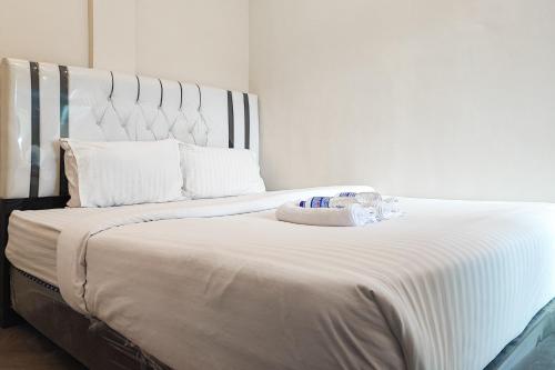 PaalmerahRedDoorz Syariah near Transmart Jambi的卧室配有白色床单和白色大床