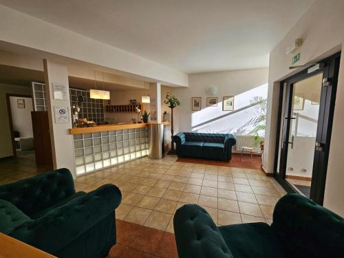 布拉格克拉里斯酒店的一间带两张绿色沙发的客厅和一间厨房