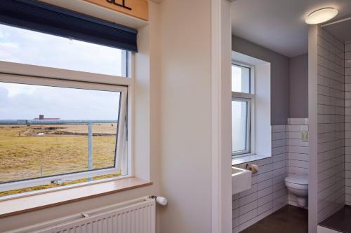 霍尔斯沃德吕尔米加德酒店的浴室设有可观赏田野景致的窗户。