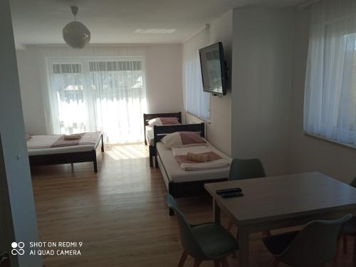 尼彻兹Bożenka的客厅配有几张床和一张桌子