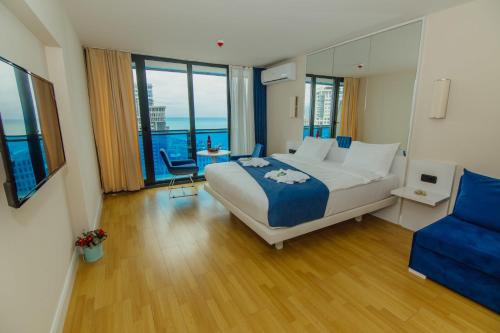 巴统Orbi Hotel City Batumi View的一间卧室配有一张大床和一张蓝色椅子