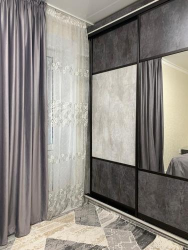 塔拉兹ИП.МЕДИНА的一间卧室配有大镜子和灰色窗帘