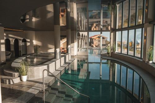 费德拉帕加内拉Solea Boutique & Spa Hotel的一座带玻璃窗的建筑中的室内游泳池