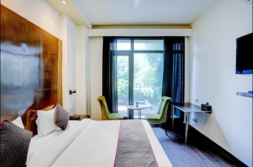 新德里The Orion - Greater Kailash的酒店客房设有床和窗户。