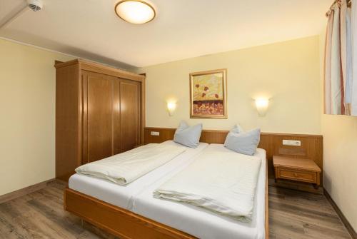 米特尔贝格IFA布赖塔赫河克勒恩瓦尔斯尔塔尔公寓的一间卧室配有一张带白色床单的大床