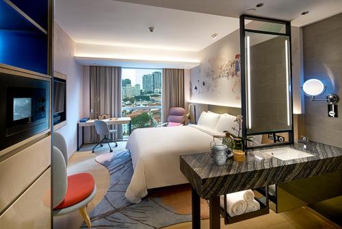 新加坡Capri by Fraser China Square, Singapore的酒店客房设有一张大床和一台电视。