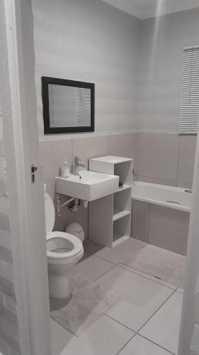 普利登堡湾Biesiesvlei 1的白色的浴室设有水槽和卫生间。