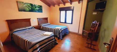 Casa para 5 personas con terreno en La Franca的客房设有两张床和窗户。