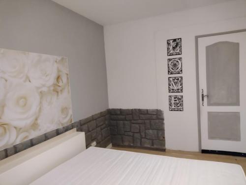 洛尔格Studio Églantine的卧室配有白色的床和砖墙