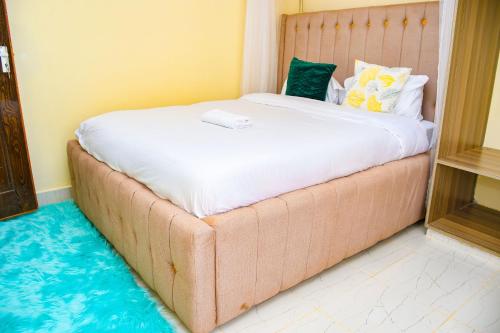 KakamegaRaven Suites的卧室配有一张带白色床垫的大床