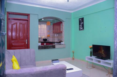 埃尔多雷特Amani Homes的客厅配有紫色沙发和红色门