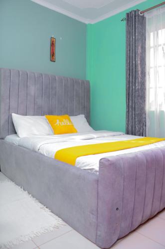 埃尔多雷特Amani Homes的一张大床,位于拥有蓝色墙壁的房间