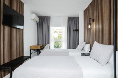 EsteponaMare Estepona Hotel的酒店客房设有两张床和电视。