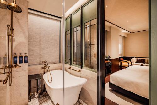 澳门Hotel Central Macau的带浴缸的浴室和1间带1张床的卧室