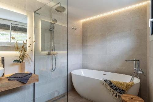 卡斯特尔德费尔斯Canela Homes COSTA CASA AILA的带浴缸和玻璃淋浴间的浴室。