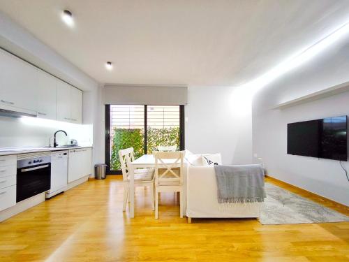 特拉萨Moderno apartamento tipo loft en Terrassa centro的厨房以及带桌椅的用餐室。