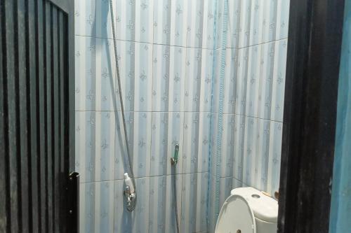 PallengukOYO 93875 Tifar House的一间带卫生间和淋浴帘的浴室