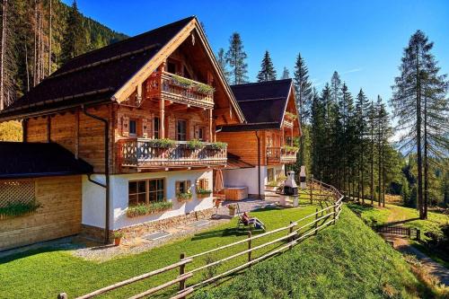 滕嫩山麓圣马丁Chalet "Ostermoasspitz" - es erwarten Sie traditionelle Gemütlichkeit kombiniert mit modernstem Komfort的前面有围栏的木屋