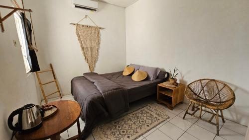 日惹Oke Baik Hostel的卧室配有1张床、1张桌子和1把椅子