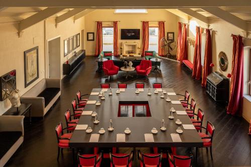 马泰拉Alvino Relais Mulino Contemporaneo的一间带桌子和红色椅子的用餐室