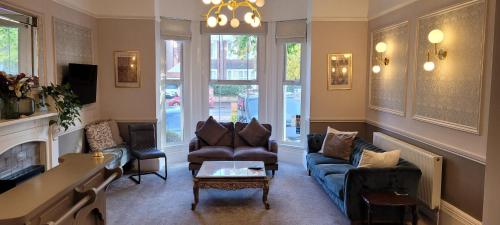 利明顿温泉Victoria Park Lodge & Serviced Apartments的客厅配有蓝色的沙发和椅子