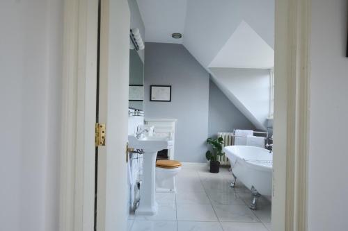 梅登黑德河畔艺术俱乐部住宿加早餐旅馆的白色的浴室设有水槽和浴缸。