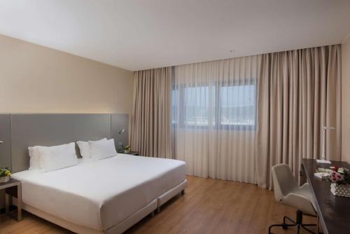 奥里奥阿塞里奥NH欧瑞欧阿尔赛瑞欧酒店的酒店客房设有一张白色大床和一张书桌