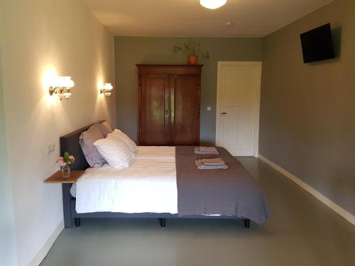 SwalmenHouterhoeve的一间卧室配有一张大床和木制床头板