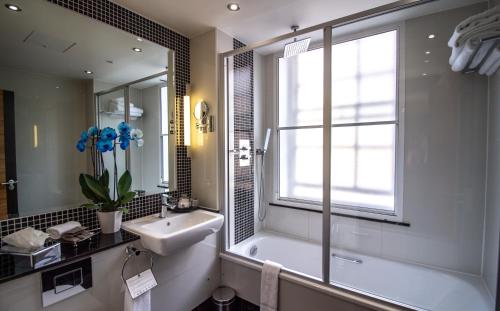 伦敦Rochester Hotel by Blue Orchid的带浴缸、水槽和窗户的浴室