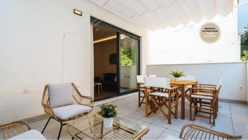 塞维利亚Magno Apartments San Martín Terrace的庭院配有木桌和椅子