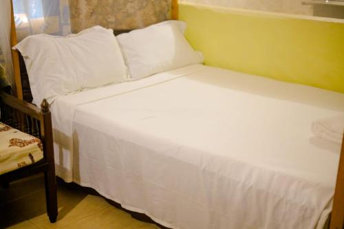 蒙巴萨Kikambala Eco Villas的一张带白色床单和枕头的床
