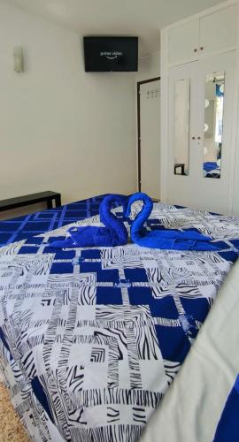 马斯帕洛马斯Sunny Room in Habitat的床上有蓝色和白色的毯子