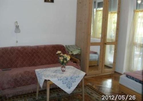 布克福尔多Wohnung in Bükfürd mit Garten的客厅配有沙发和鲜花桌