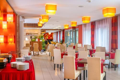 维谢格拉德皇家俱乐部酒店的用餐室配有桌椅和黄色灯光