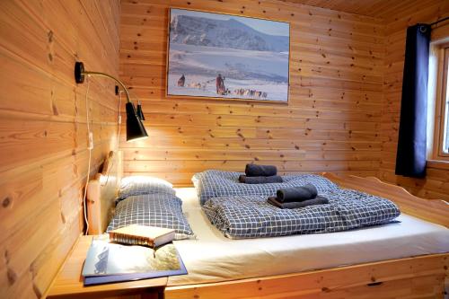InnsetCabin Huskyfarm Innset的卧室配有木墙内的两张床
