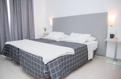 圣米格尔德阿沃纳GOLF PARK Resort的一间卧室配有一张带黑白毯子的床